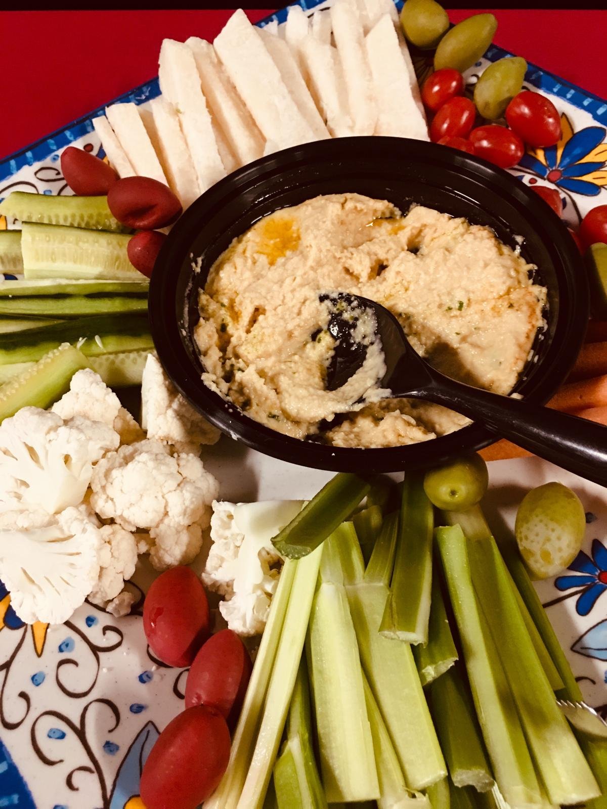 Hummus with cauliflower, celery, cucumber and olives.