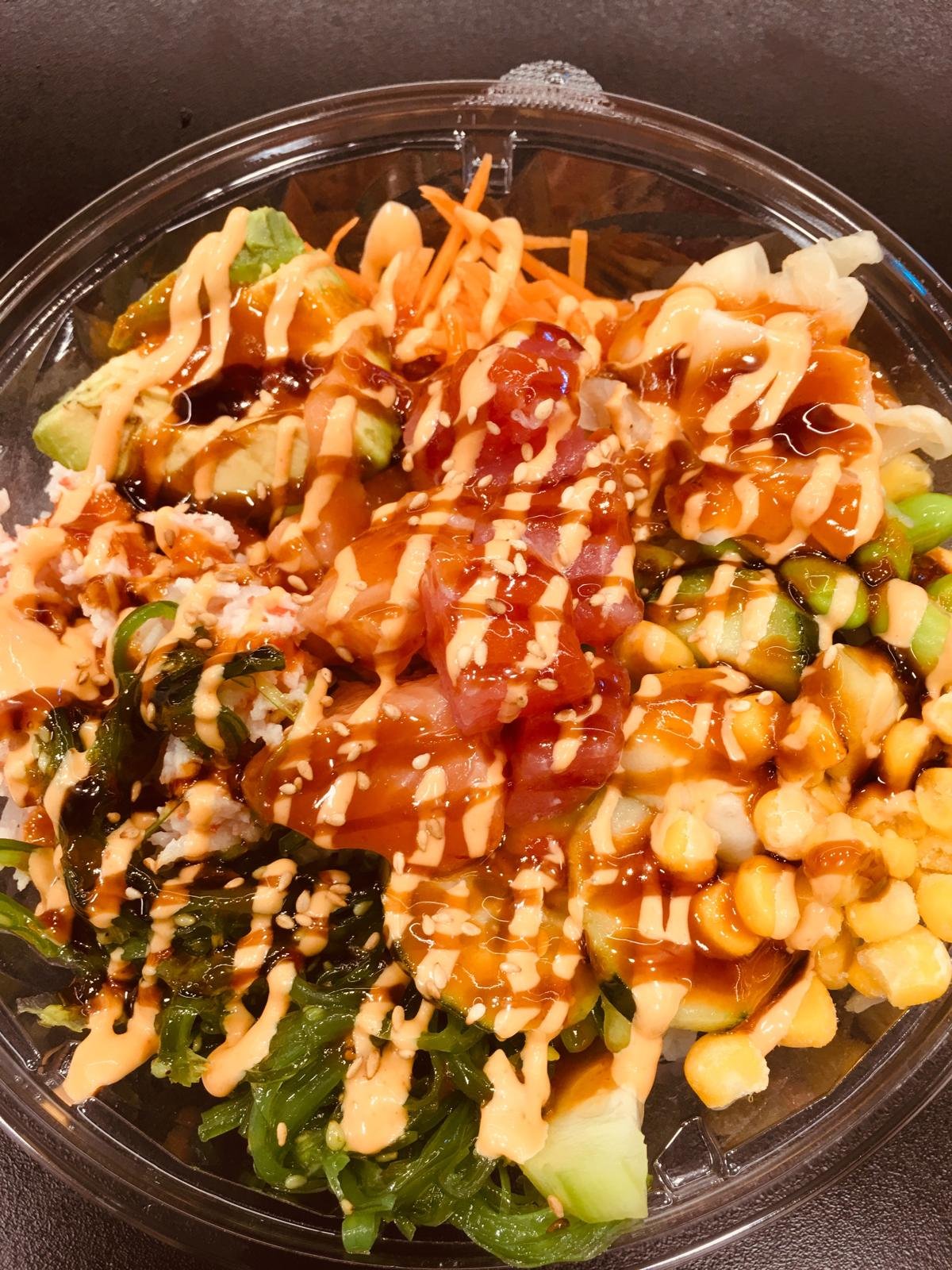 A poke bowl drizzled with sauce.