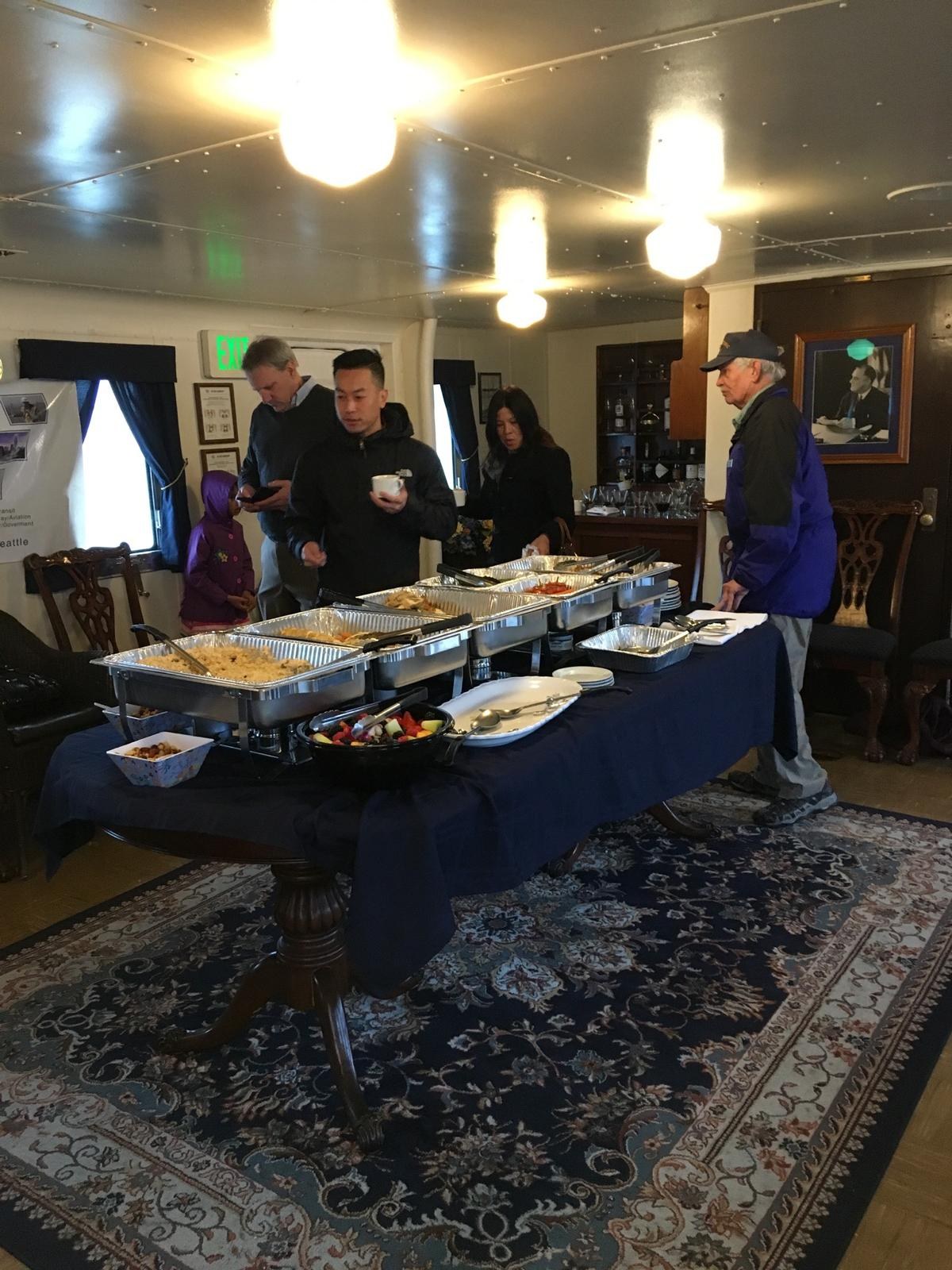 A buffet line of chafing dishes in a wood-panelled club room.